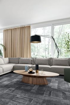 a living room with a large sectional couch and coffee table in front of a window