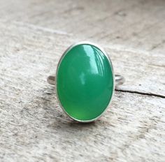 This bright green chrysoprase has been set in sterling silver with a handmade ring band from sterling silver half dome wire. This ring is simple and elegant. The lovely bright green chrysoprase is 18mm x 13mm in size. Made to order! Chrysoprase Emerald Ring With Oval Cabochon For Gift, Handmade Green Emerald Oval Cabochon Ring, Green Oval Chalcedony Rings, Oval Green Chalcedony Rings, Oval Turquoise Chrysoprase Ring, Bohemian Turquoise Chrysoprase Ring, Handmade Elegant Chrysoprase Ring, Handmade Green Chalcedony Rings, Bohemian Green Chrysoprase Ring