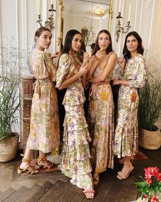 four beautiful women standing in front of a mirror