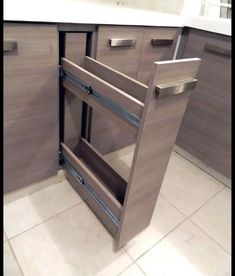 a kitchen with gray cabinets and tile flooring in the middle is shown, there are no drawers on each side