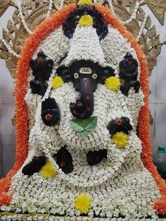 an elaborately decorated statue in the shape of a person's head with flowers on it