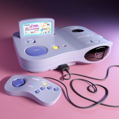 an old computer game console and controller on a pink surface with a purple light in the background