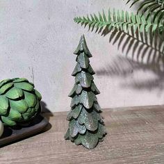 a ceramic christmas tree next to an artichoke