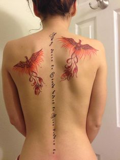 the back of a woman's body with tattoos on her upper and lower back