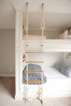 there is a bunk bed with a ladder on the bottom and two pillows below it