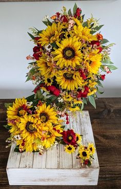 a bouquet of sunflowers and other flowers sitting on a wooden box with white background