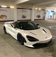 a white sports car parked in a parking lot