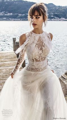 a woman in a wedding dress sitting on a dock by the water with her hands on her hips