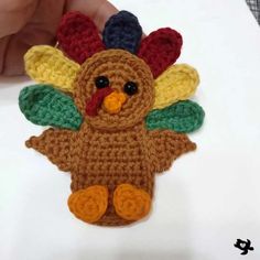 a crocheted turkey ornament being held by someone's hand