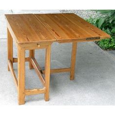 a wooden table sitting on top of a sidewalk