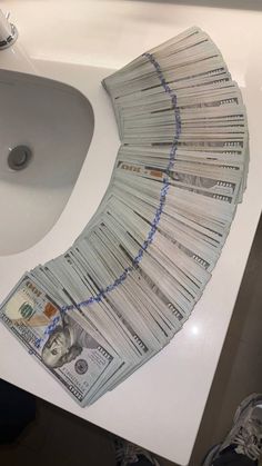 a pile of money sitting on top of a bathroom sink