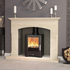 a fireplace with a clock on the wall above it and candles in front of it