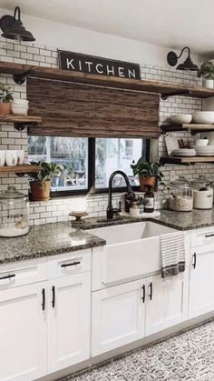 a kitchen filled with lots of white cabinets and counter top space next to a window