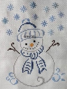 a cross stitch snowman is shown in blue and white