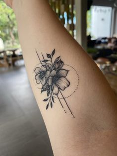 a woman's arm with a flower tattoo on the left side of her arm