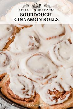 a close up of a cinnamon roll with icing on it and the title text reads little spoon farm sourdough cinnamon rolls