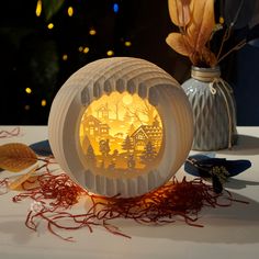 a paper lantern sitting on top of a table next to some dried leaves and flowers