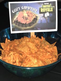 a bowl filled with tortilla chips next to a sign that reads coty campfire