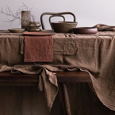 the table is covered with linens and dishes