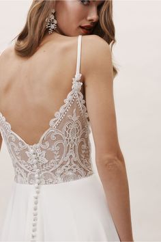 the back of a woman's wedding dress with beading and pearls on it