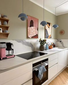 a kitchen with white cabinets and marble counter tops