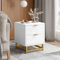 a white cabinet with gold handles and drawers in a living room next to a chair