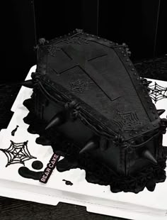 a cake with black frosting and decorations on it