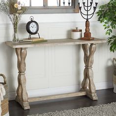 a wooden table with a clock on top of it next to a potted plant