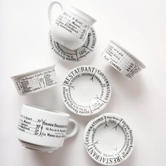 four coffee cups and saucers with words written on them