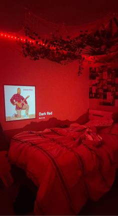 a bedroom with red lights and a bed in the corner that has a television on it