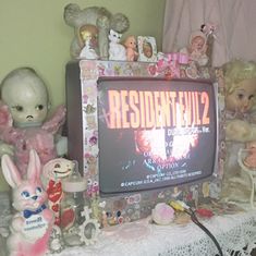 an old television sitting on top of a table next to stuffed animals and other toys