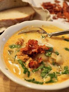 a white bowl filled with soup next to slices of bread