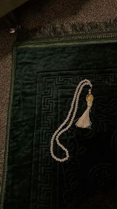 a green rug with a tasseled bead on it