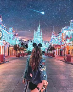 a person walking down a street with a mickey mouse ears on their head and the sky in the background