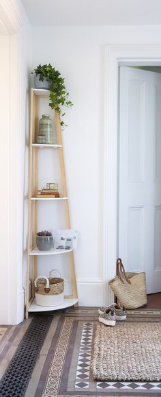 a room with a ladder and baskets on the floor in front of it, next to a door