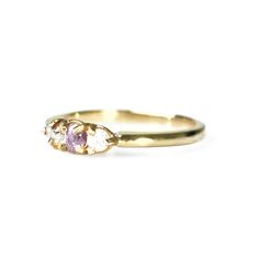 a yellow gold ring with two pink stones on the front and one white stone in the back