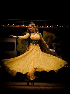 a woman in a yellow dress dancing on stage