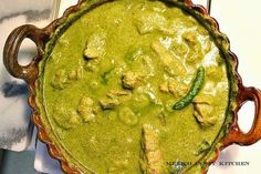 a pan filled with green food on top of a table