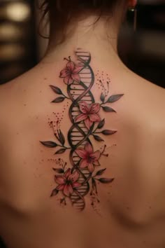 the back of a woman's neck with flowers and a tattoo design on it