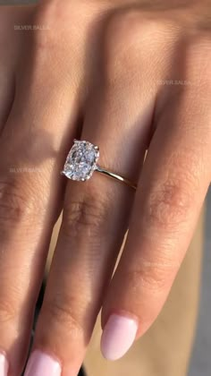 a woman's hand with a diamond ring on it