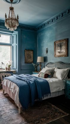 a bed sitting in a bedroom next to a window with a chandelier hanging above it