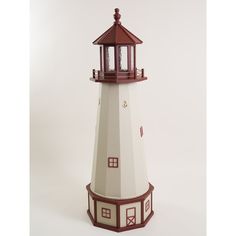 a small white and red lighthouse with a brown roof on it's side against a white background