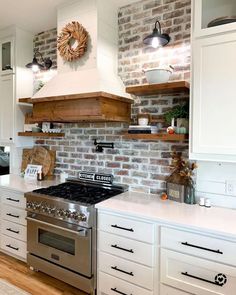 a kitchen with white cabinets and brick wall