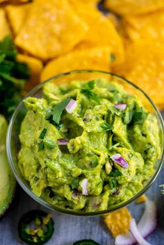 guacamole in a glass bowl surrounded by tortilla chips