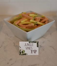 a bowl filled with orange and green pretzels next to a sign that says jungle vines