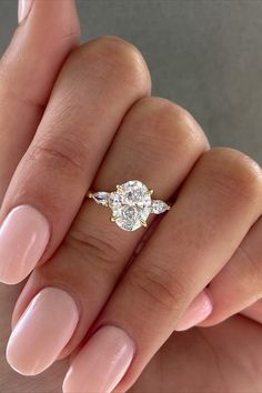 a woman's hand with a ring on it and a diamond in the middle