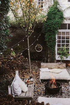 an outdoor fire pit in the middle of a yard with lots of trees and plants