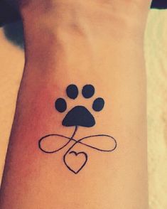 a dog paw and heart tattoo on the wrist