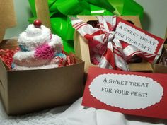 a box filled with lots of treats next to a sign that says a sweet treat for your feet