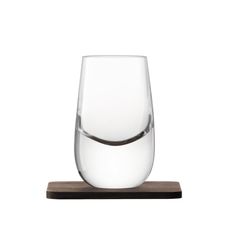 a wine glass sitting on top of a wooden coaster